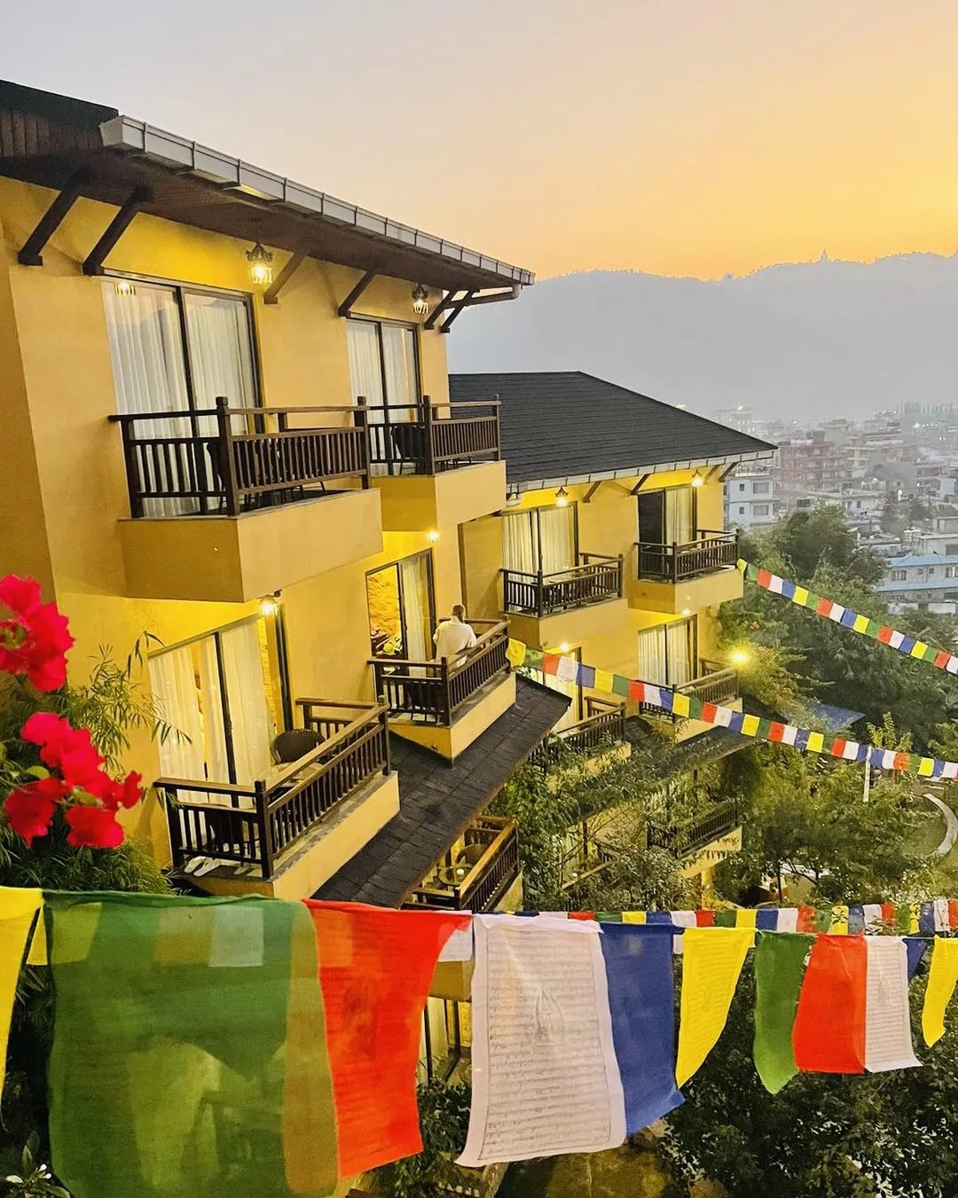 Timber balconies and prayer flags at Bar Peepal Resort at sunset