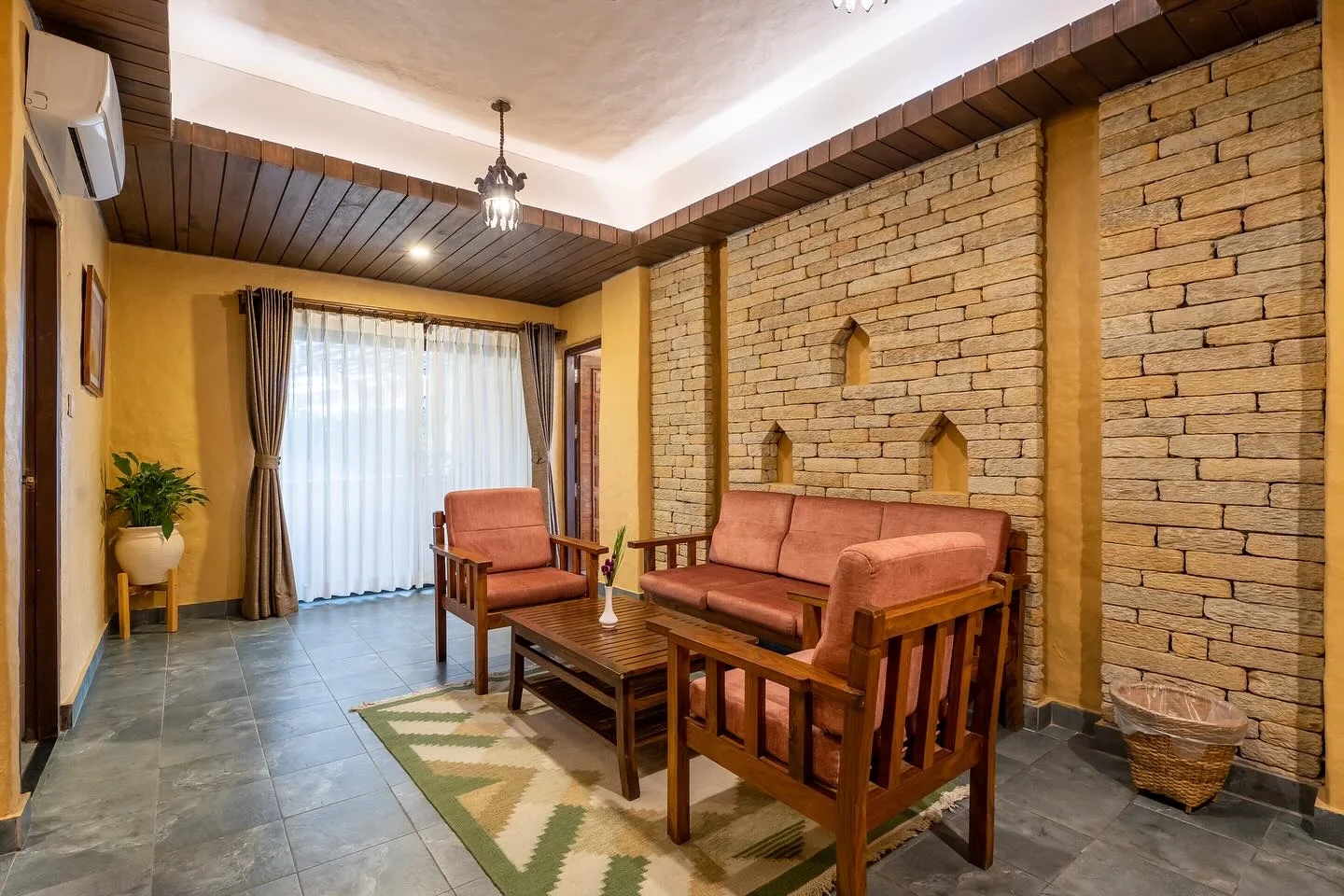 Junior Suite sitting lounge with stone walls and timber sofas