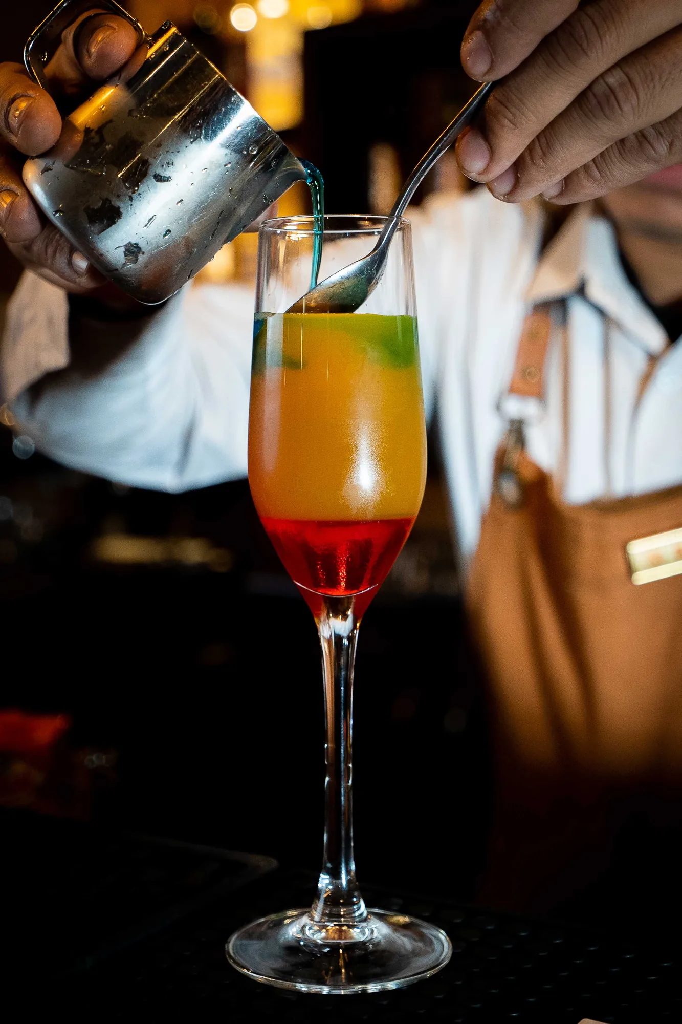 A cocktail being poured at the bar